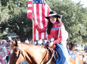 Brittany Moreno, a member of the Rodeo Sweethearts, leading the parade. The precision horseback riding drill team can be seen  near the front of the parade or performing before the rodeo.